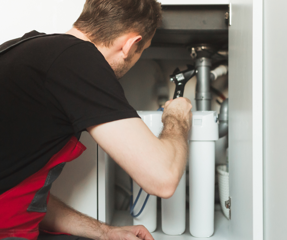 A technician works on a whole-home water filtration system